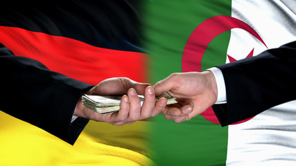 Germany and Algeria officials exchanging money, flag background, partners