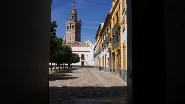 POV walkthrough doorway heading towards Seville Cathedral's Moorish Giralda tower, Sevilla, Andalusia, Spain