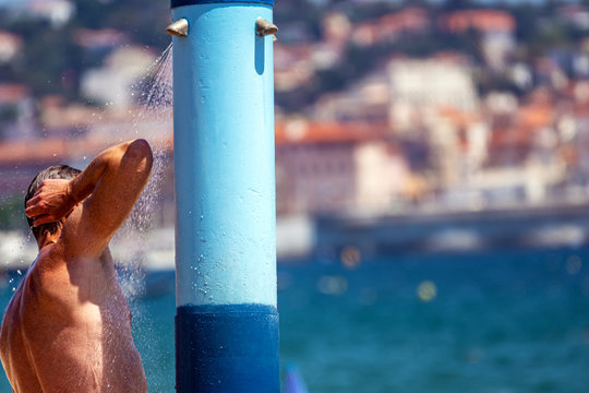 ein Mann duscht an einem &ouml;ffentlichen Strand an der Cote d'azur