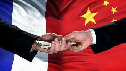 France and China officials exchanging money, flag background, weapon trade