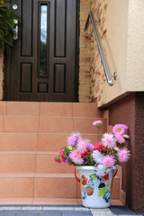 Piękna kolorowa dekoracja z kolorowych kwiatów i wiaderka na schodach domu.	 - obrazy, fototapety, plakaty