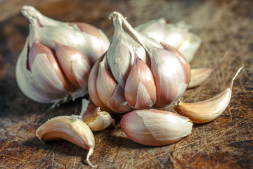 Organic garlic,Closeup garlic on wooden texture on for cooking on dark background, concept healthy lifestyle.Fresh peeled garlics and bulbs.