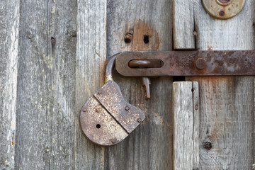 The old big padlock on wooden door