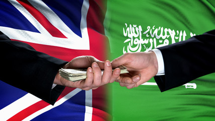 Great Britain and Saudi Arabia officials exchanging money, flag background