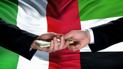 Italy and UAE officials exchanging money, flag background, cooperation concept