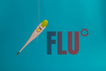Thermometer next to the flu inscription on a blue background. Cold and flu concepts. Healthcare, medicine, flu and treatment concept