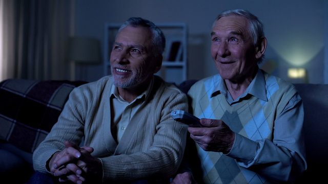 Happy Aged Men Watching Tv At Night Holding Remote Control, Nursing Home Leisure