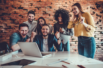 Group of young business team celebrating success at office.
