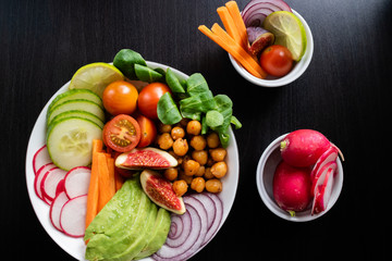 Buddha bowl made with organic vegetables and two cups with other ingredients. Top view.