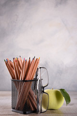 Group of school supplies pencils and books on wooden table over a grey background