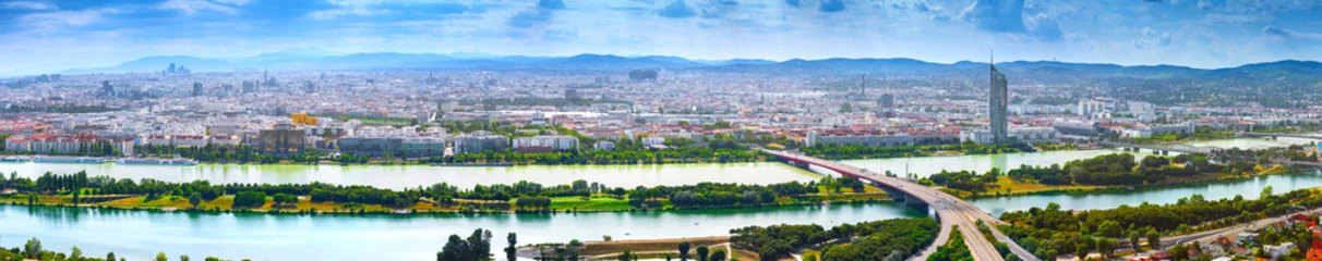 Foto op Plexiglas Prachtige luchtfoto panoramisch stadsgezicht uitzicht Oostenrijkse hoofdstad Wenen. Moderne wolkenkrabbers van glasbeton in de oude stad aan de oevers van de Donau - van de grootste rivier van Europa. Warme zomerdag © Sodel Vladyslav