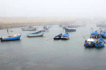  artisanal fishing boats  berthed in the morocco asilah port in a misty day 