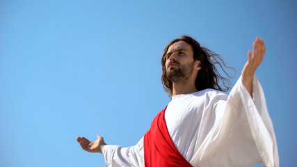 Saint man looking at sky with opened hands, Jesus resurrection and ascension