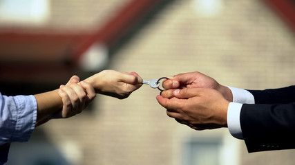 Man and woman pulling key from house, division of property after divorce closeup