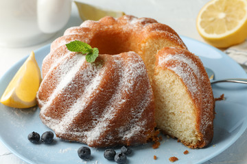Cake with powdered sugar, blueberry and mint on white background, close up