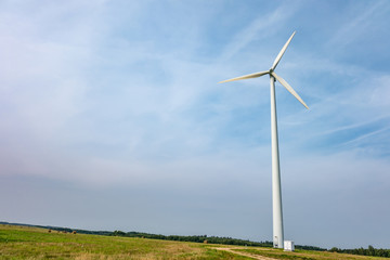 rotating blades of a windmill propeller on blue sky background. Wind power generation. Pure green energy.