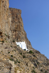 Photo of picturesque Monastery of Panagia Hozoviotissa built on a steep cliff with view to Aegean...