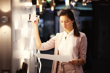 Female interior designer chooses lighting for her new project