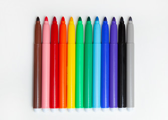 Multi-colored felt-tip pens, markers on white.