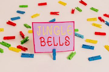 Conceptual hand writing showing Jingle Bells. Concept meaning Most famous traditional Christmas song all over the world Colored clothespin papers empty reminder white floor office