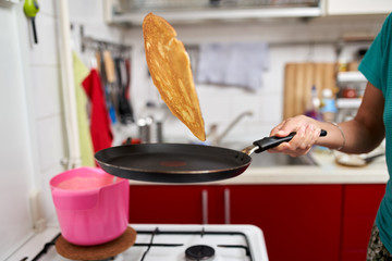 Woman flipping pancake in the pan