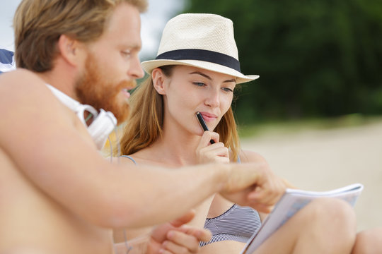 Woman Doing Sudoku On The Beach