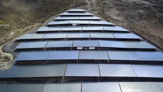 Solar panel farm, alternative green eco-friendly energy. Panels rows along the dry lands. Huge Photovoltaic from an aerial drone point. Top view.