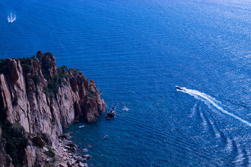 Cliffs at sea with motorboat