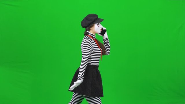 Mime girl going somewhere, talking on the phone. Chroma key.