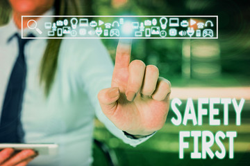 Handwriting text writing Safety First. Conceptual photo Avoid any unnecessary risk Live Safely Be Careful Pay attention Woman wear formal work suit presenting presentation using smart device