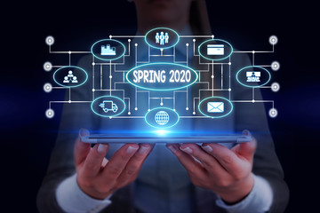 Text sign showing Spring 2020. Business photo showcasing time of year where flowers rise following winter season Woman wear formal work suit presenting presentation using smart device