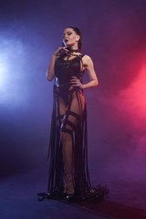 Young sexy woman dancer posing in the smoke