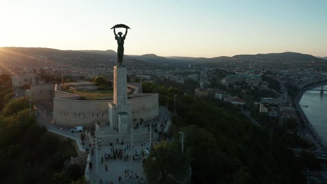 dusk flying clockwise around Liberty Statue revealing view of Budapest 