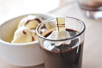 Dessert cup of chocolate with cream and ice cream on background