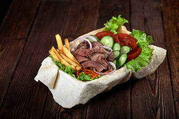 Turkish and Arabic Traditional Ramadan mix kebab plate. Kebab beef on lavash bread with sauce and vegetables.