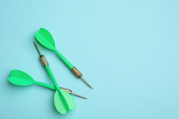 Green dart arrows on blue background, flat lay with space for text