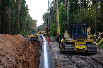 Natural gas pipeline construction work. A dug trench in the ground for the installation and...
