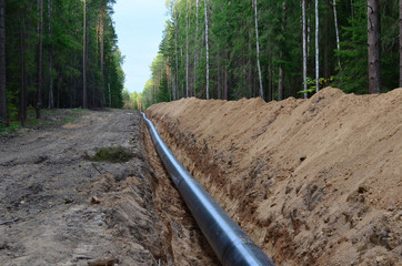 Natural gas pipeline construction work. A dug trench in the ground for the installation and...