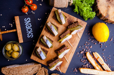 Sandwich with smoked mackerel fish with spices on dark stone background. Smoked fish, mediterranean...