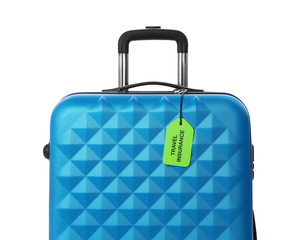 Blue suitcase with TRAVEL INSURANCE label on white background