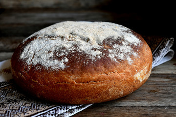 Homemade bread, folk napkin on a wooden table.
