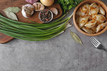 Delicious cooked dumplings with fried onion on grey table, flat lay. Space for text