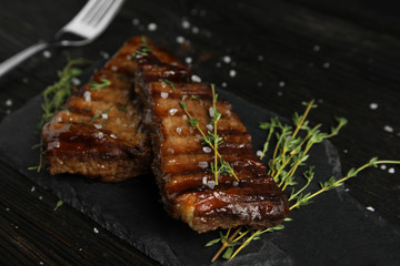 Board with grilled meat on wooden table