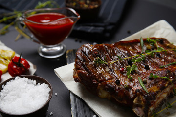 Board with grilled meat on black background, closeup