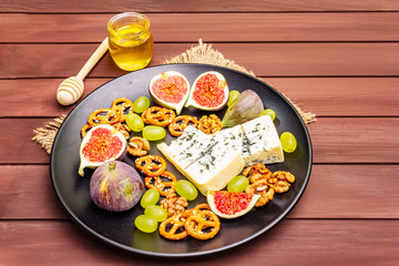 Cheese plate with blue cheese, honey, walnuts, figs, grapes, pretzels