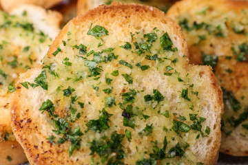 Slices of toasted bread with garlic and herbs as background, closeup