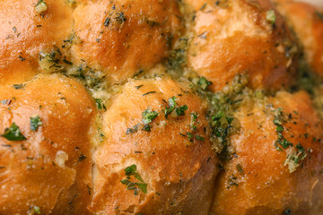 Buns of bread with garlic and herbs as background, closeup
