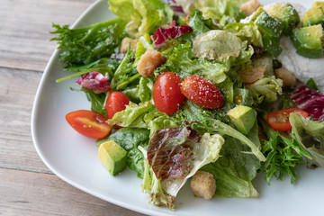 caesar salad fresh vegetable mix avocado with red tomato on top