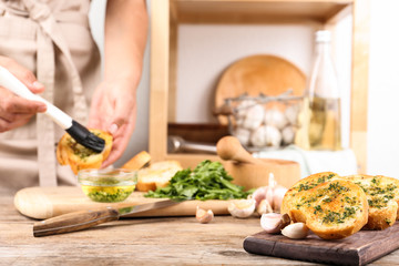 Slices of toasted bread with garlic and blurred woman on background. Space for text