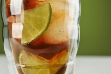 Glass of tasty ice tea with lime, closeup